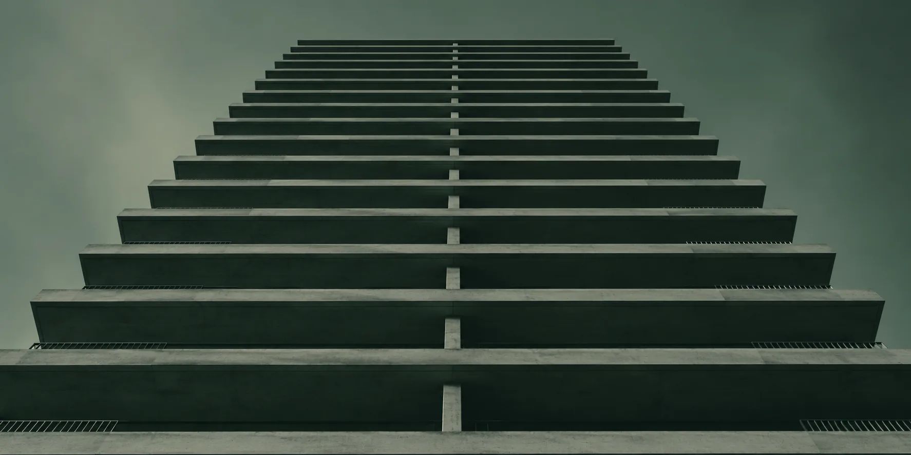 Repeating concrete balcony slabs of a tower seen from below